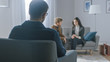 Unfocused Couple on Counseling Session with Psychotherapist. Focus on Back of Therapist Taking Notes and Talking: People Sitting on Analyst Couch, Discussing Psychological and Relationship Problems