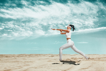 Sticker - Sporty and fit young woman athlete relaxed after training at the desert. Cloudy day on coast. The concept of a healthy lifestyle and sport. Woman in white sportswear.