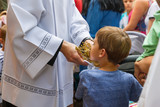 Dziecko całujące relikwie świętego.