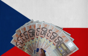 Czech Republic flag with Euro banknotes in the hand