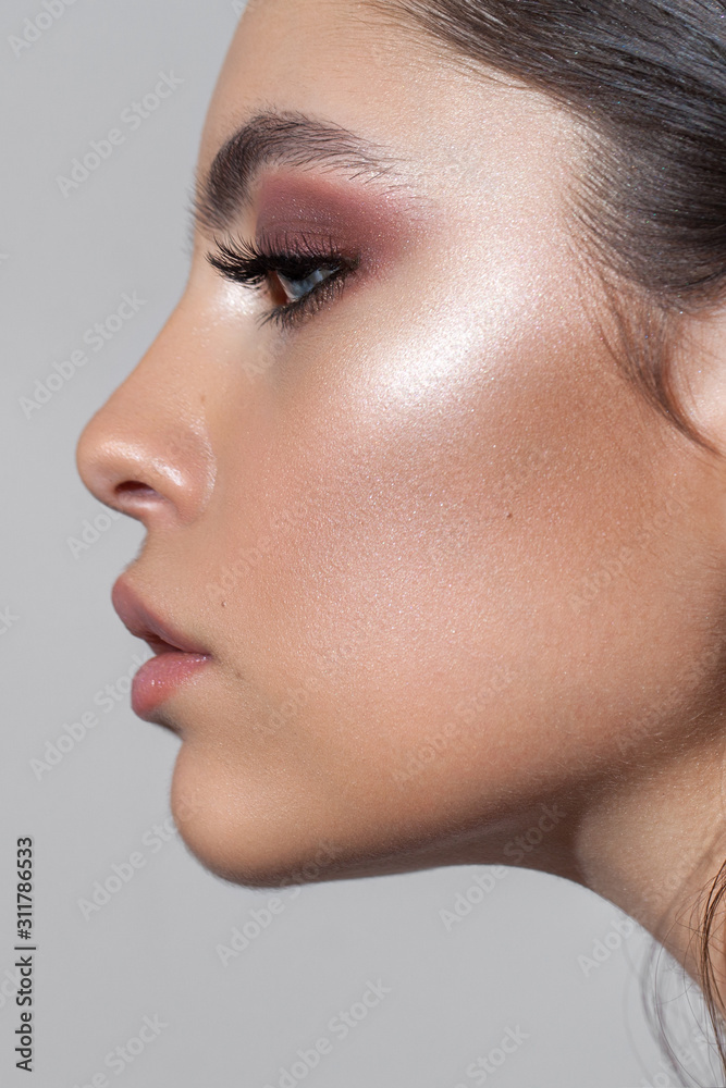 Profile photo of a beautiful girl with professional makeup, ideal skin, rose eyeshadows and nude lips. - obrazy, fototapety, plakaty 