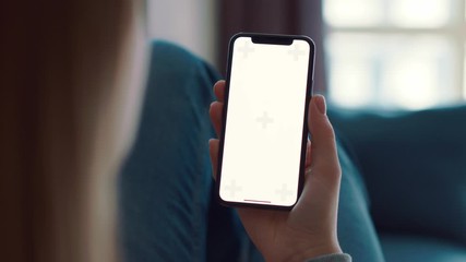 Colour tracking mock-up for watching content closeup. Woman lying on blue sofa and using smartphone device. Legs and point of view to cell surfing. Green white screen, slow motion. Shoot on ARRI ALEXA