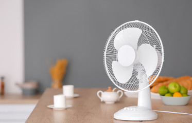 Electric fan on table in kitchen