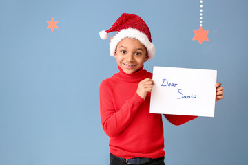 Wall Mural - Cute African-American boy with letter to Santa Claus on color background