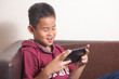 © airdone - Young Asian boy playing online games on tablet smart phone