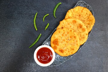 Wall Mural - Freshly fried Masala stuffed Aloo puri or Kachori served hot with tomato ketchup and Green chilies