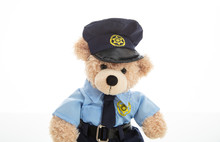 Cute Teddy In Policeman Uniform Isolated Against White Background