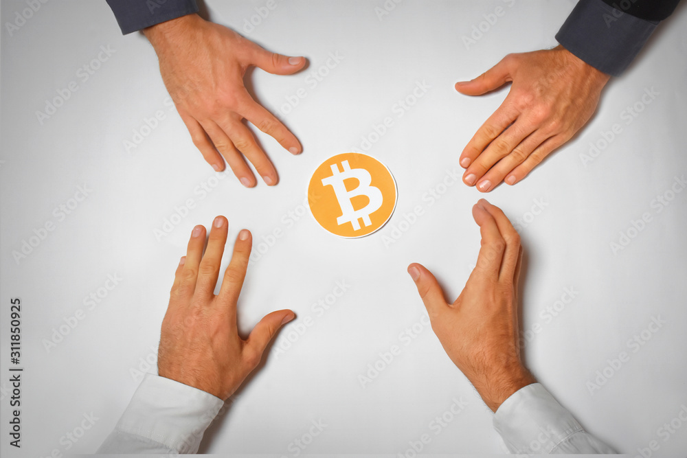 hands reaching for Bitcoin symbol