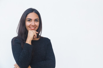 Happy positive female customer touching chin, looking at camera, smiling. Beautiful young woman in casual sweater posing isolated over white background. Advertising concept