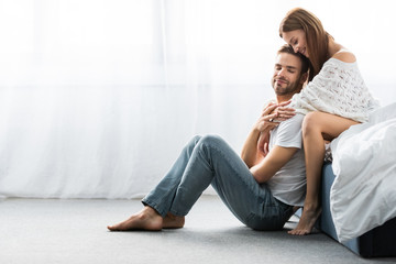 Wall Mural - attractive and smiling woman hugging handsome man with closed eyes