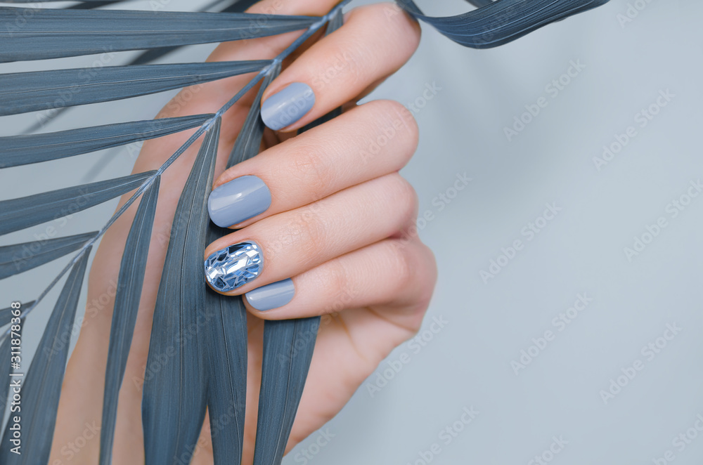Foto Beautiful female hand with blue nail design