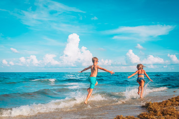 Poster - happy girl and boy run, kids fly and play with waves on beach