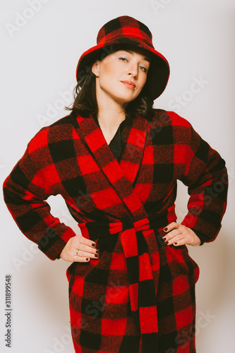 Αφίσα Studio portrait of beautiful woman wearing checked red and black coat and a hat,