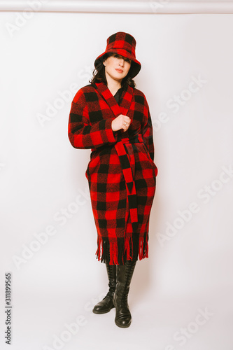 Εκτύπωση καμβά Studio portrait of beautiful woman wearing checked red and black coat and a hat,