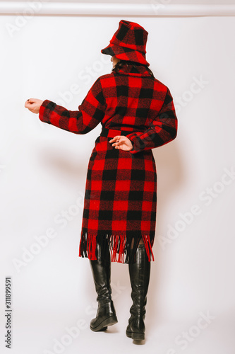 Ταπετσαρία τοιχογραφία Studio portrait of beautiful woman wearing checked red and black coat and a hat,