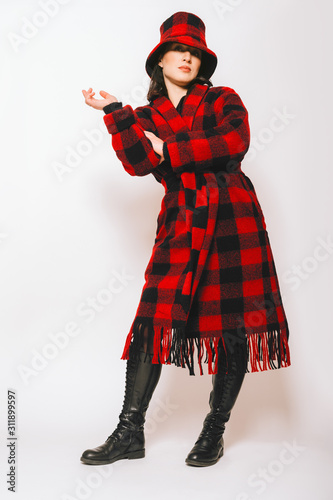 Εκτύπωση καμβά Studio portrait of beautiful woman wearing checked red and black coat and a hat,