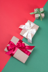 Wall Mural - Beautiful packaging of presents with satin ribbons, craft paper on red and green background.