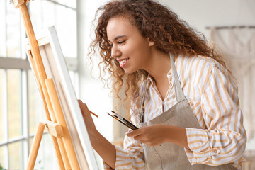 Wall Mural - Beautiful female African-American artist painting in studio