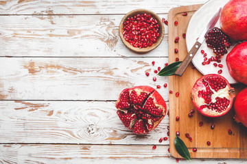 Board with tasty pomegranate on wooden table