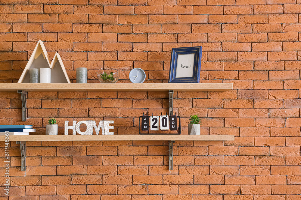 Shelves with decor hanging on brick wall