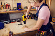 © Aleksej - Young handy woman with short blond hair working with screwdriver.