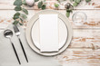 Beautiful table setting with empty menu on white wooden background