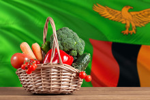 Zambia Organic Food Concept. National Flag Background With Basket Full Of Vegetables On Wooden Table. Copy Space For Text.