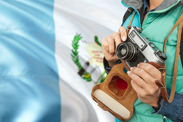 Wall Mural - Guatemala photographer concept. Close-up adult woman holding retro camera on national flag background. Adventure and traveler theme.