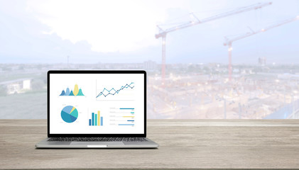 Aufkleber - modern laptop on wood table showing charts and graph against blue business building background