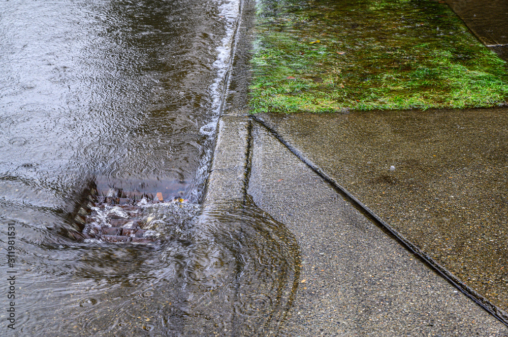 Heavy rain caused flooding in street, water swirling around storm drain ...