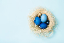 Easter Eggs In Blue Colors In A Nest. Copy Space. The Concept Of Stylish Decoration For Easter, Greeting Cards, Etc. Flat Lay