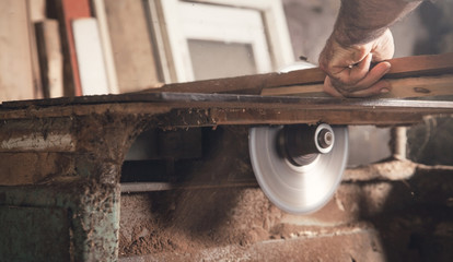 Poster - Carpenter cutting a piece of wood with a carpentry machine.