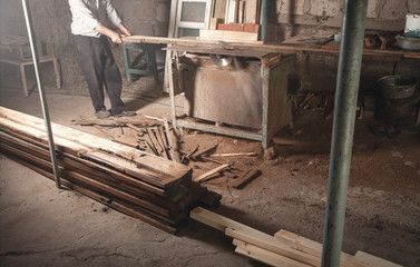 Poster - Carpenter cutting a wooden plank with a carpentry machine.