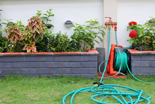 Watering Hose Equipment In Green Grass Of Backyard