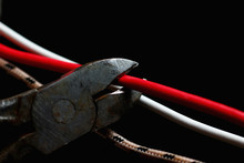 Wire Cutters Cutting A Red Wire On A Dark Background