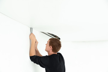 Wall Mural - Repairman installing white stretch ceiling in room