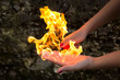 Hand on fire, young female hand with a lighter, playing with fire