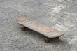 Closeup old skateboard with shadow on cement floor background
