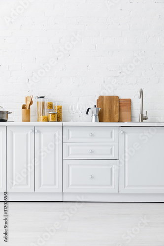 Fotomural minimalistic modern white kitchen interior with kitchenware near brick wall
