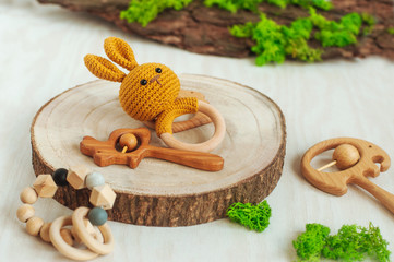 Wall Mural - Wooden baby teether toys on light background with natural details