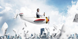 Fototapeta Sport - Businessman in aviator hat driving plane