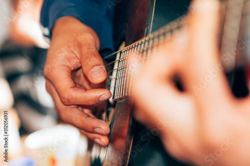 Fotografía close-up on male hands playing a classical guitar
