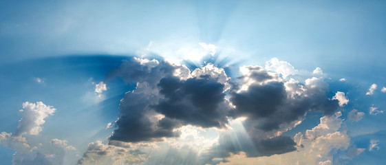rays of light with dramatic sky. cumulus sunset dark clouds with sun setting down on dark background