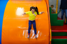 Lovely Little Girl On A Children's Slide