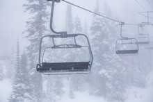 Whistler, British Columbia, Canada. Ski Lift Chairs On The Mountain During A Cloudy And Foggy Winter Day.