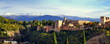 im Abendlicht erstrahlte Alhambra in Panoramaansicht vor schneebedeckter Sierra Nevada