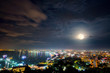 High view on viewpoint full moon above cityscape with colorful light at the sea beach of ​​Pattaya Bay, beautiful landscape Pattaya City at night scene landmark in Chonburi, Travel Asia to Thailand