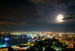 High view on viewpoint full moon above cityscape with colorful light at the sea beach of ​​Pattaya Bay, beautiful landscape Pattaya City at night scene landmark in Chonburi, Travel Asia to Thailand