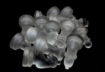 Classic glass chess pieces on a glass board. Conceptual photo on a black background.