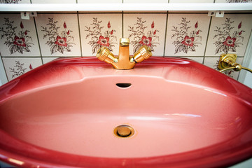 Wall Mural - Vintage pink sink with gold faucet and flower pattern tiled wall in bathroom